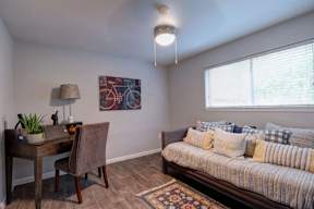A room with a bed, desk, and chair.