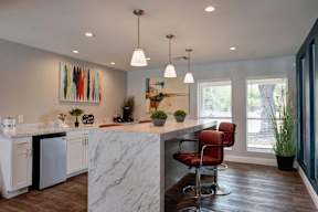 A kitchen with a marble countertop and a white fridge.