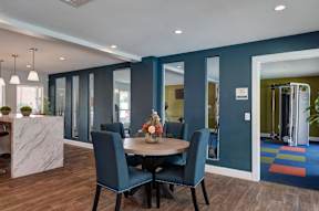 A dining room with a table and chairs.