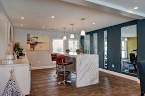 A modern kitchen with a white countertop and a marble island.