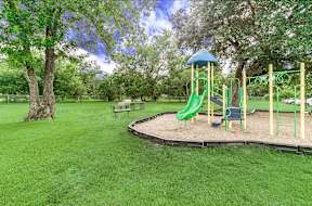 A playground with a green slide and a blue roof.