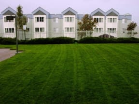 a large green lawn in front of an apartment building