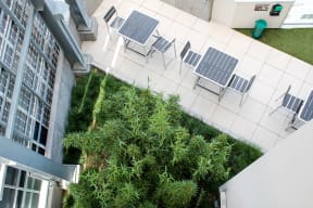 a terrace with chairs and tables and grass and plants