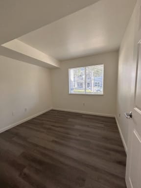 a empty room with wood floors and a window