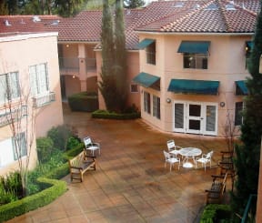 a patio with a table and chairs in front of a building