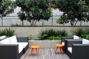 an outdoor patio with chairs and orange stools
