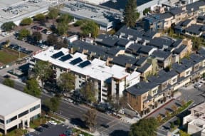 an aerial view of an urban neighbourhood with buildings and cars