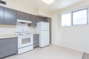 an empty kitchen with white appliances and stainless steel cabinets