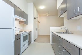 an empty kitchen with white appliances and stainless steel counters