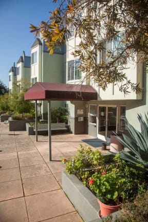 a patio in front of a building with a red awning