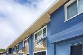 the side of a building with blue siding and windows