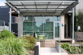 the patio of a building with tables and chairs and glass windows