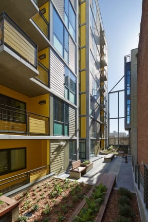 the courtyard between the two buildings is filled with benches and plants