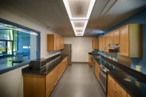an empty kitchen in a building with wood cabinets and black counter tops