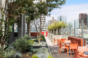 a roof terrace with tables and chairs and a view of the city