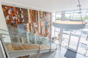 a lobby with a spiral staircase and a wall of colorful quilts