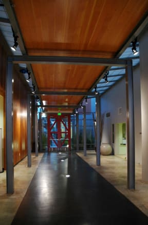 a long hallway with steel columns and a wood ceiling