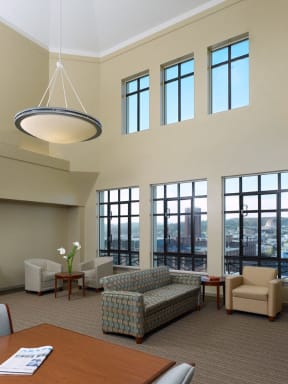 a room with couches chairs and a table and windows