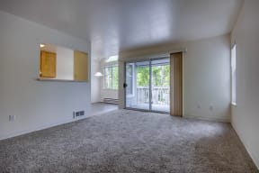an empty living room with a door to a balcony