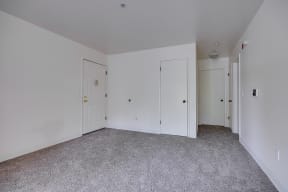 a bedroom with white walls and carpet and two doors