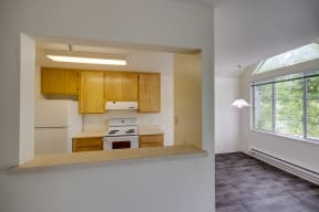 the view of a kitchen from the living room with a large window