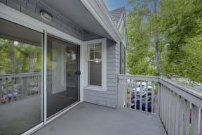 a covered porch with a door to a patio with trees