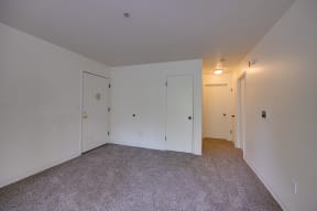 a bedroom with white walls and carpet and white doors