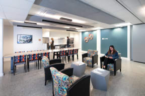 a woman sitting in a chair in a room with tables and chairs