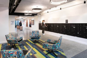 a hallway with chairs and lockers and a woman standing in the middle