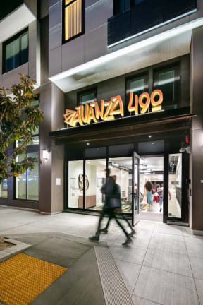 a man walking in front of a building with a sign on it