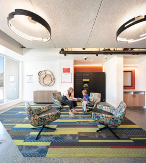 a woman and a child sitting in a lobby with chairs