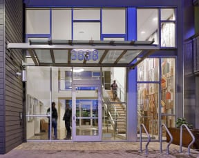 the front of a building with glass doors and a staircase