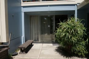 a patio with a bench and a sliding glass door