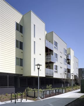 a row of apartment buildings with balconies and a sidewalk