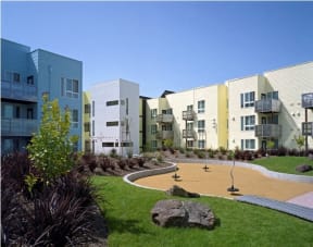 a group of apartment buildings with a park in front of them
