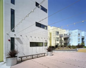 the side of a white building with a wooden walkway