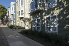 a row of green and white houses on a sidewalk