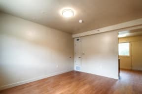 an empty living room with white walls and a wooden floor