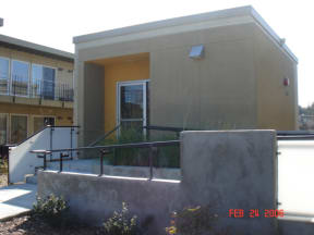 the front of a building with stairs and a glass door