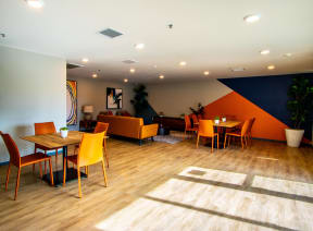 a dining room with orange chairs and tables and a blue and orange wall