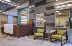 a lobby with chairs and a table and a reception desk