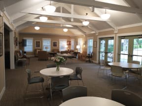 a dining room with tables and chairs and a large room with couches and chairs