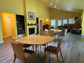A living room with a fireplace and a dining table.
