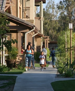 a group of people walking down a sidewalk