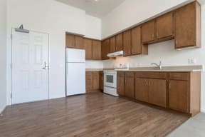 an empty kitchen with wooden cabinets and a white refrigerator
