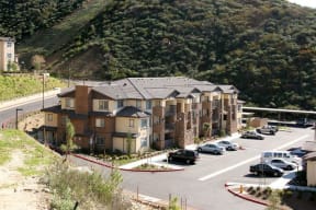 an apartment building with cars parked in a parking lot