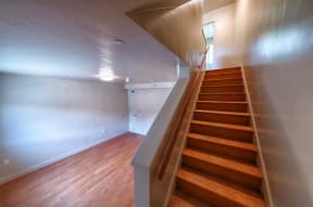 a staircase in a house with wood floors and white walls