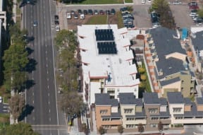an aerial view of a building with solar panels on the roof