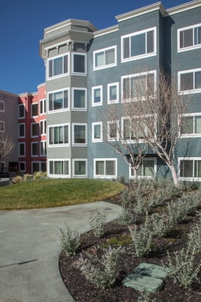 an exterior view of an apartment building with an empty parking lot