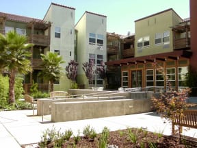a group of apartments with a courtyard and chairs